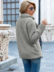 Giacca in pile grigio donna, stile casual, indossata con jeans. Moda autunnale, look urbano, tessuto caldo e morbido. Perfetta per giornate fredde.