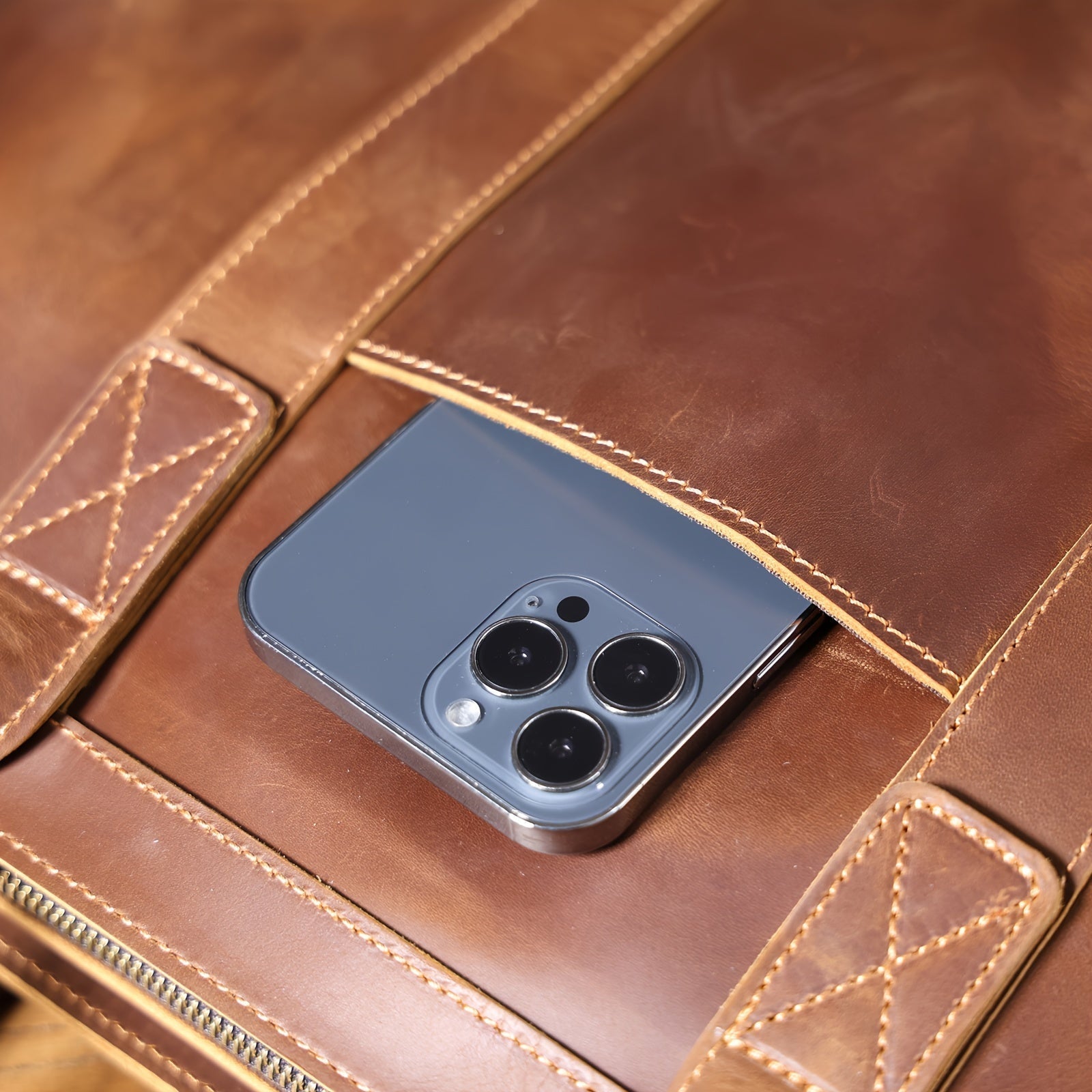 Smartphone moderno con tripla fotocamera in una custodia di pelle marrone. Tecnologia avanzata, design elegante, accessori di lusso.
