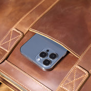 Smartphone moderno con tripla fotocamera in una custodia di pelle marrone. Tecnologia avanzata, design elegante, accessori di lusso.