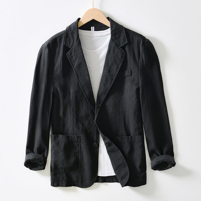Giacca nera casual da uomo in cotone, appesa su gruccia, con t-shirt bianca sotto. Moda elegante, abbigliamento maschile, stile moderno.