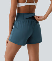 Donna in pantaloncini sportivi blu scuro con tasca nascosta, vista posteriore. Abbigliamento fitness traspirante, ideale per allenamenti e yoga.