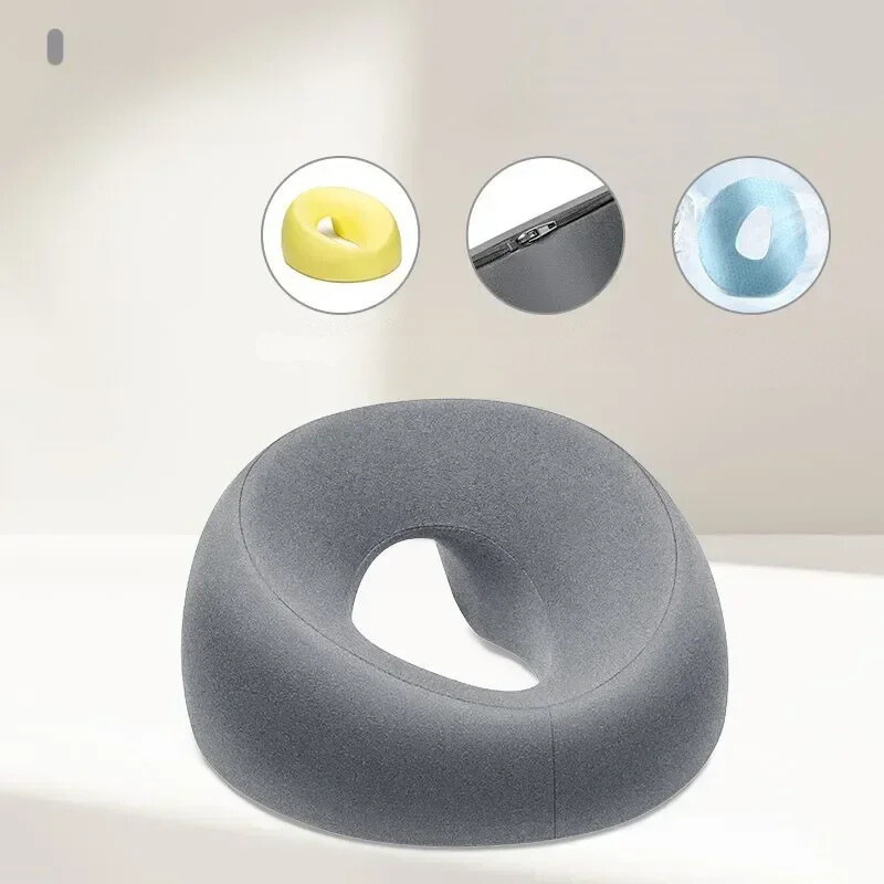 Cuscino ergonomico grigio per seduta, design a ciambella, supporto lombare, ideale per ufficio e casa. Include varianti colore giallo e blu.