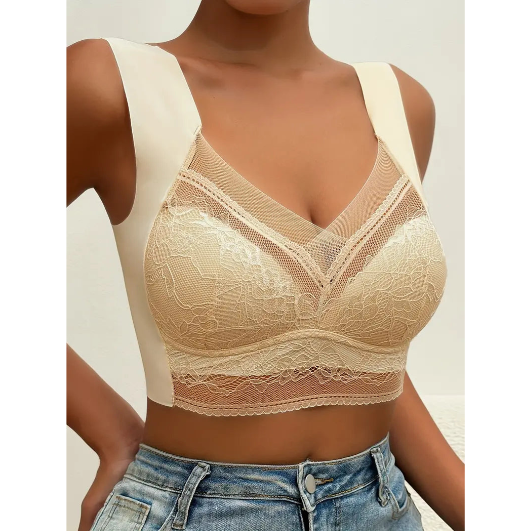 Reggiseno in pizzo beige con spalline larghe, design a V trasparente, indossato con jeans. Intimo femminile elegante e confortevole.