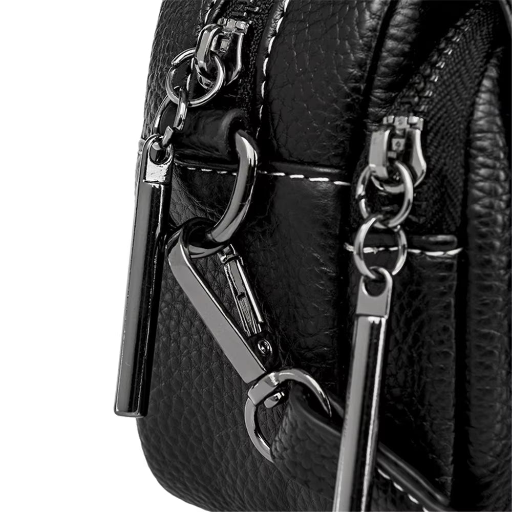 Borsa in pelle nera con dettagli metallici lucidi, doppia cerniera e cuciture bianche. Design elegante e moderno, accessorio moda di tendenza.