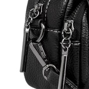 Borsa in pelle nera con dettagli metallici lucidi, doppia cerniera e cuciture bianche. Design elegante e moderno, accessorio moda di tendenza.