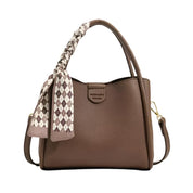 Borsa a mano marrone in pelle con manico intrecciato e foulard a quadri. Elegante accessorio moda donna, perfetto per ogni occasione.