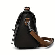 Borsa a tracolla in pelle nera con dettagli marroni, vista laterale. Design elegante, chiusura con zip, accessorio moda donna.