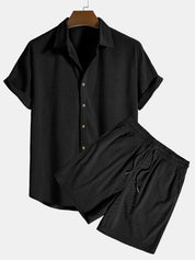 Completo estivo uomo nero, camicia a maniche corte con bottoni e pantaloncini coordinati. Abbigliamento casual, tessuto leggero, moda estiva.