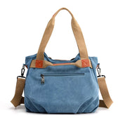 Borsa a tracolla in tela blu con manici beige, tasca frontale con zip, dettagli in pelle marrone. Design casual e spazioso per uso quotidiano.