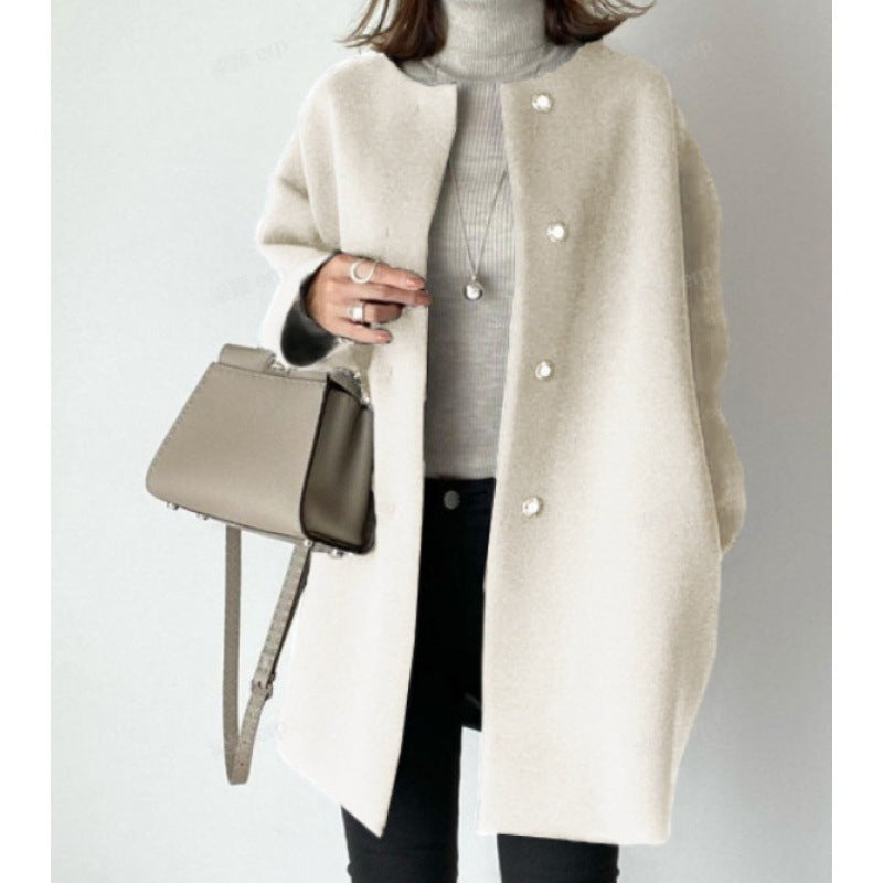Cappotto donna beige elegante, abbinato a maglione grigio e borsa a tracolla marrone. Moda autunnale, stile casual chic.