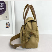 Borsa a tracolla in tela beige con manici marroni, design moderno e spazioso, ideale per viaggi e uso quotidiano. Accessorio moda versatile.