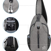Zaino monospalla grigio con porta USB, tasca per bottiglia, foro per auricolari. Design moderno, ideale per viaggi e attività all'aperto.
