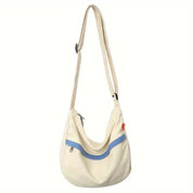 Borsa a tracolla beige con dettagli blu, design moderno, chiusura a zip, ideale per uso quotidiano. Accessorio moda donna, stile casual.