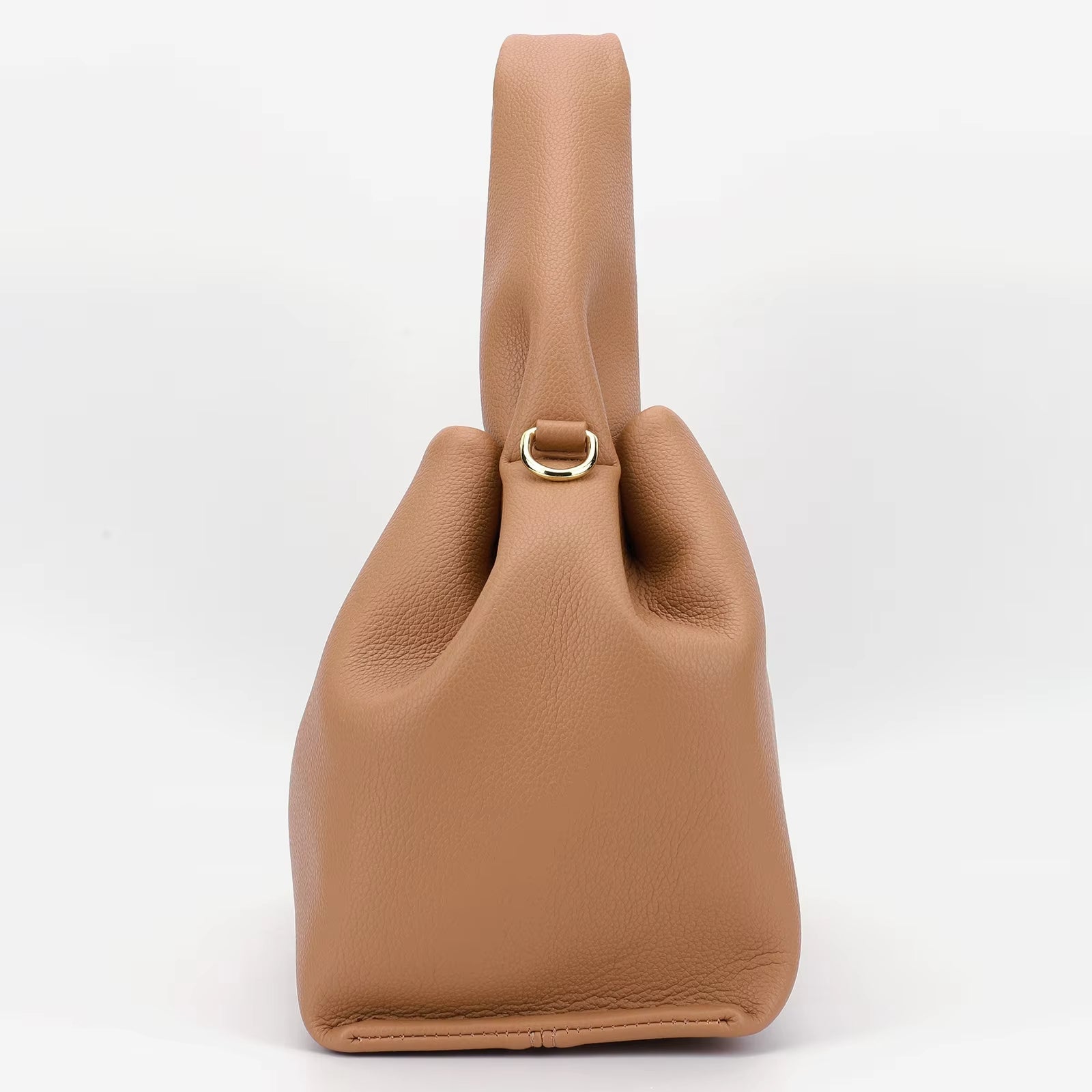 Borsa a mano in pelle marrone chiaro, design moderno con chiusura ad anello dorato. Accessorio elegante per donna, moda autunno 2023.