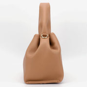 Borsa a mano in pelle marrone chiaro, design moderno con chiusura ad anello dorato. Accessorio elegante per donna, moda autunno 2023.