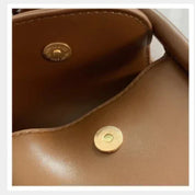 Borsa in pelle marrone con chiusura magnetica dorata, design elegante e moderno, ideale per moda donna, accessorio di lusso.