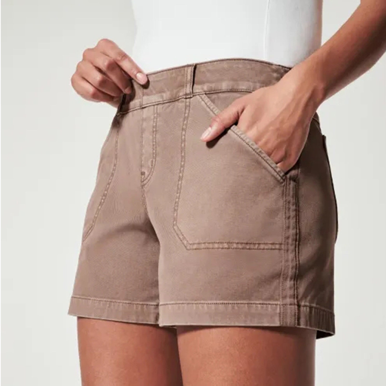 Shorts marroni da donna in cotone, con tasche frontali, indossati da una modella. Abbigliamento estivo casual, moda femminile, stile comodo.