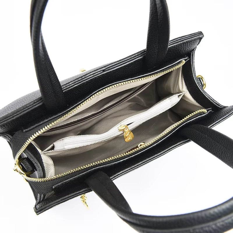 Borsa a mano in pelle nera con cerniera dorata, interno foderato beige, tasca interna con zip. Elegante accessorio moda donna.