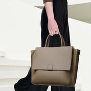 Borsa a mano in pelle marrone, design elegante e moderno, indossata da una persona. Accessorio moda donna, ideale per ufficio e occasioni formali.