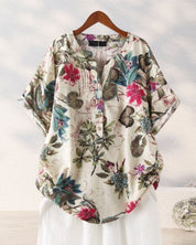 Camicia donna floreale in cotone, maniche corte, sfondo bianco, bottoni frontali, design casual estivo. Moda femminile, abbigliamento leggero.
