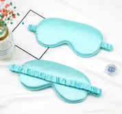 Mascherina per dormire in seta azzurra su sfondo bianco, con elastico arricciato. Accessorio per il sonno, relax, benessere.