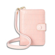 Portafoglio donna rosa in pelle con texture coccodrillo, chiusura a bottone, cinturino da polso. Accessorio moda elegante e funzionale.