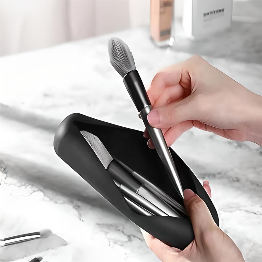 Mani che estraggono un pennello da trucco da un astuccio nero su un tavolo di marmo. Set pennelli cosmetici, accessori bellezza, trucco professionale.
