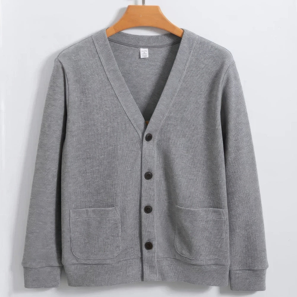 Cardigan grigio in cotone, design classico con scollo a V, bottoni frontali e tasche applicate. Moda uomo, abbigliamento casual elegante.
