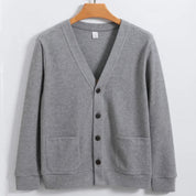 Cardigan grigio in cotone, design classico con scollo a V, bottoni frontali e tasche applicate. Moda uomo, abbigliamento casual elegante.