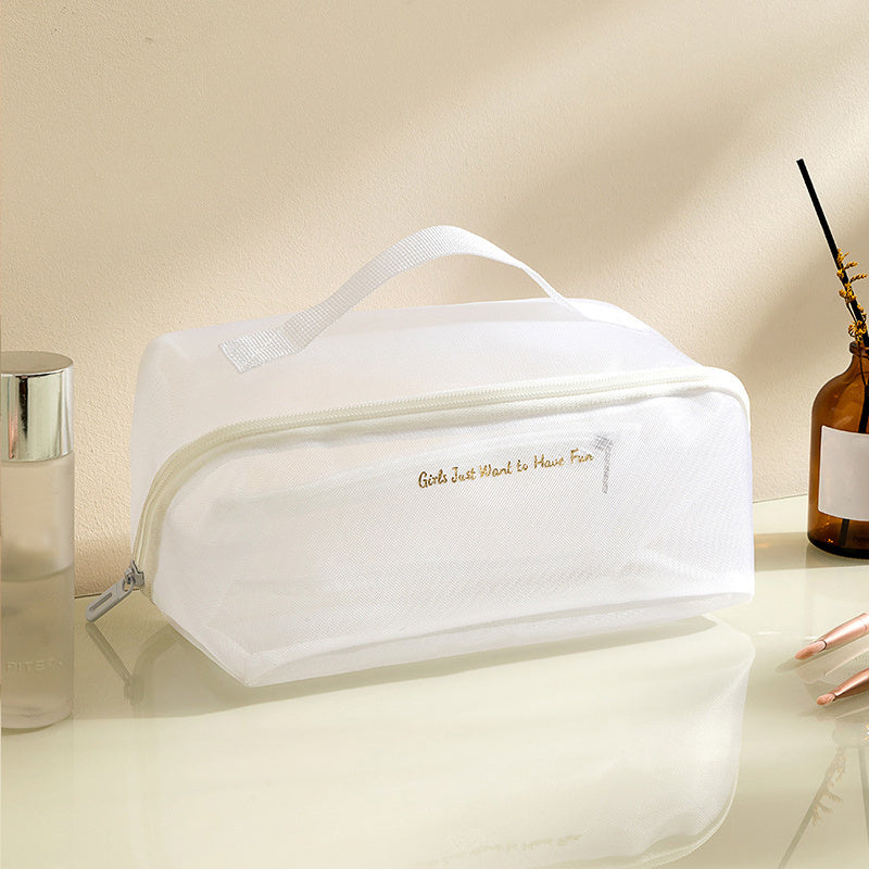 Borsa cosmetica bianca trasparente con cerniera, manico superiore, su tavolo da toeletta. Ideale per organizzare trucchi e accessori da viaggio.