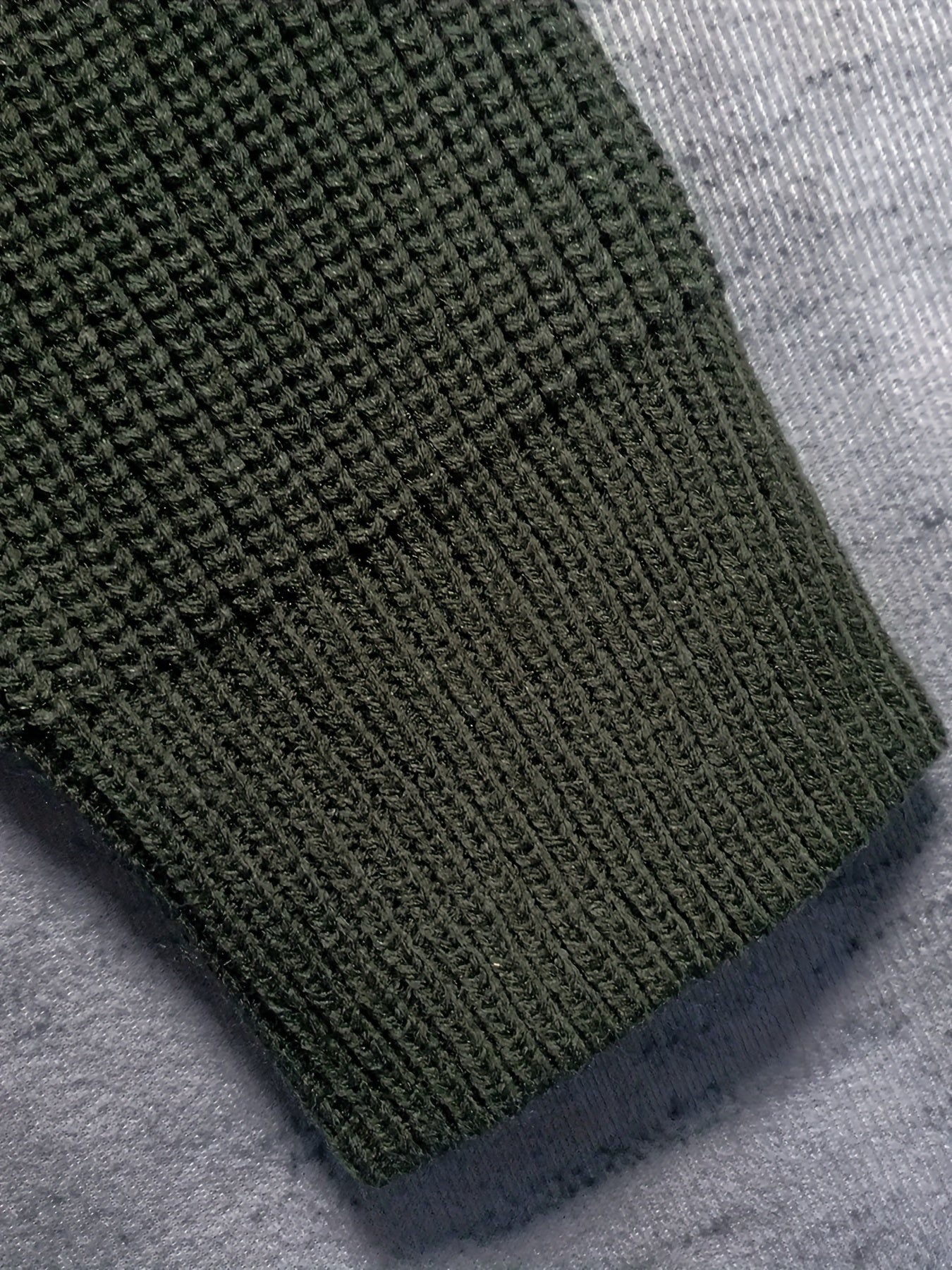 Maglione verde scuro a maglia grossa, dettaglio manica, tessuto caldo e morbido, ideale per l'inverno. Stile casual, moda uomo e donna.