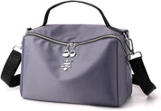 Borsa a tracolla viola in nylon impermeabile con cerniera, manico superiore e tracolla regolabile nera, design moderno e pratico per donna.