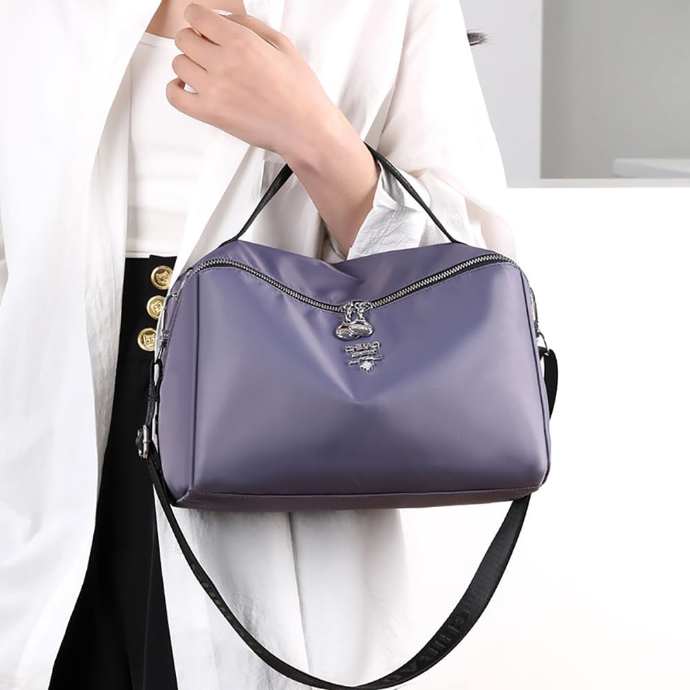 Borsa a tracolla viola in pelle, design elegante, chiusura con zip, manico superiore, indossata da una donna. Accessorio moda femminile.