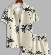 Completo estivo uomo con camicia e pantaloncini beige, stampa palme nere, stile casual, perfetto per vacanze e moda mare.