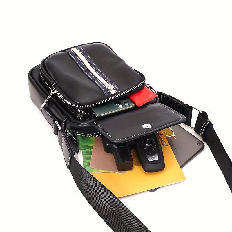 Borsa a tracolla in pelle nera con zip, contenente smartphone, chiavi, documenti e portafoglio. Design elegante e funzionale per uomo e donna.