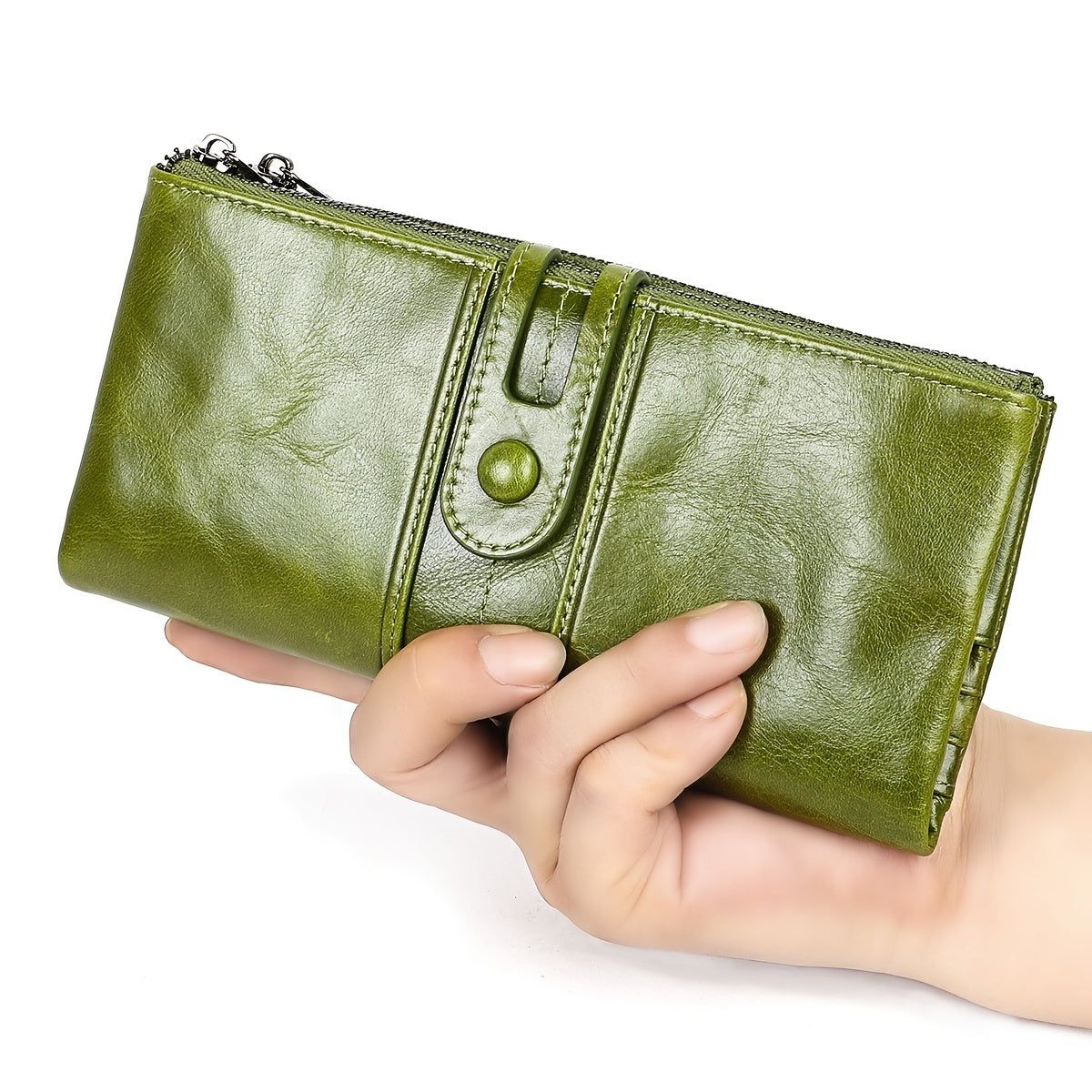 Portafoglio donna in pelle verde, chiusura a bottone, design elegante, tenuto in mano. Accessorio moda, alta qualità, ideale per shopping.