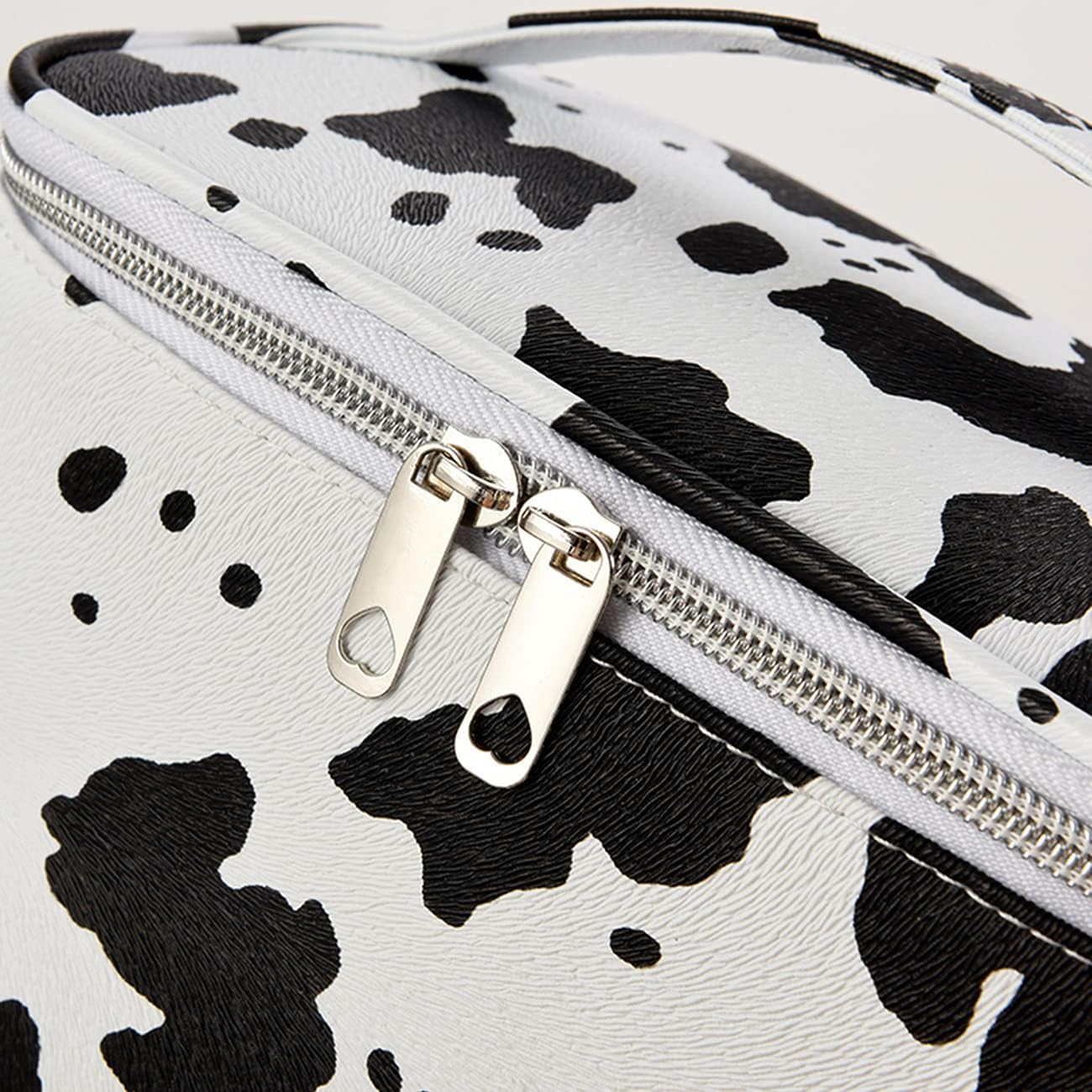Borsa a tracolla in ecopelle bianca e nera con stampa mucca, chiusura a zip argentata, design moderno, accessorio moda donna.