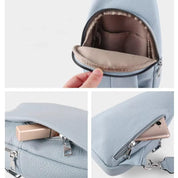 Zaino in pelle blu chiaro con cerniera, tasche interne ed esterne, ideale per smartphone e accessori. Design elegante e pratico per l'uso quotidiano.