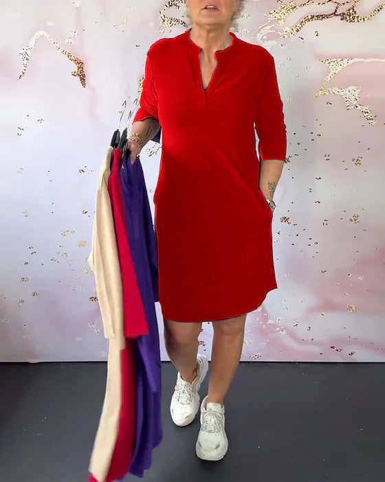 Donna in abito rosso con maniche a tre quarti, tiene abiti colorati su grucce. Sfondo chiaro con dettagli dorati. Moda femminile casual.