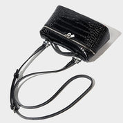 Borsa a tracolla nera in pelle effetto coccodrillo, design elegante con zip argentata, ideale per moda donna. Accessorio chic e versatile.