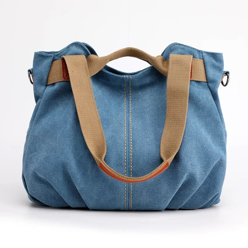 Borsa a mano in denim blu con manici beige, design casual e spazioso, ideale per uso quotidiano. Accessorio moda donna, stile versatile e pratico.
