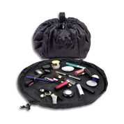 Borsa trucco nera aperta con cosmetici, pennelli e accessori. Organizer portatile per make-up, ideale per viaggi e uso quotidiano.