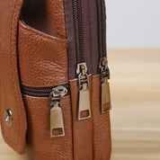 Borsa a tracolla in pelle marrone con doppie cerniere metalliche, design elegante e pratico, ideale per uomo e donna. Accessorio moda versatile.