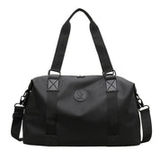 Borsone da viaggio nero in tessuto impermeabile, con manici regolabili e tracolla removibile. Design elegante e spazioso per viaggi e sport.