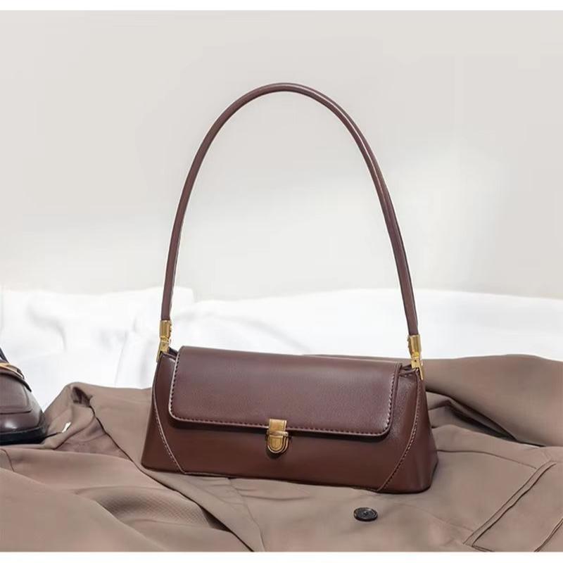 Borsa a spalla marrone in pelle su cappotto beige, design elegante e moderno, accessorio moda donna, ideale per look autunnali e invernali.