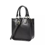Borsa a mano in pelle nera lucida con manici e tracolla regolabile, design elegante e moderno, ideale per moda donna e accessori di lusso.