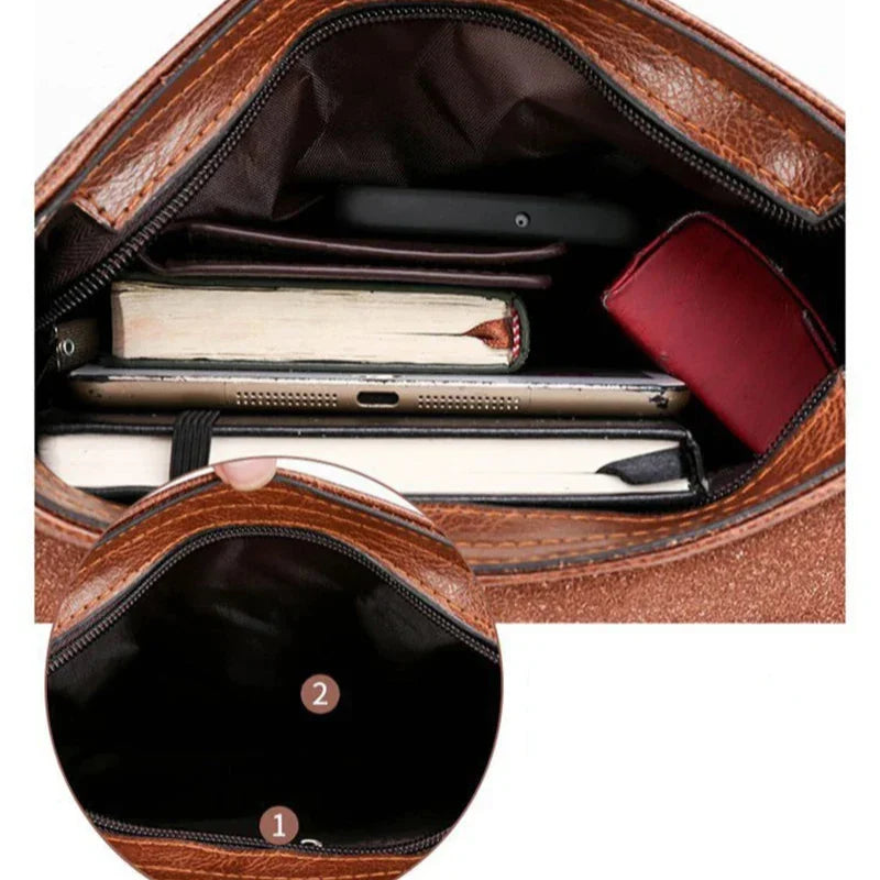 Interno di una borsa in pelle marrone con libri, smartphone e portafoglio rosso. Design spazioso, ideale per organizzazione e praticità quotidiana.