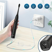 Spazzolino elettrico nero in carica, con cavo USB collegato a una presa a muro. Design moderno, tecnologia avanzata, igiene orale efficace.