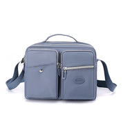 Borsa a tracolla in pelle blu con tasche multiple e cerniere, design elegante e funzionale, ideale per uomo e donna, perfetta per uso quotidiano.