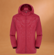 Giacca a vento rossa con cappuccio, design moderno, tessuto impermeabile, ideale per attività outdoor e sport, su sfondo arancione.
